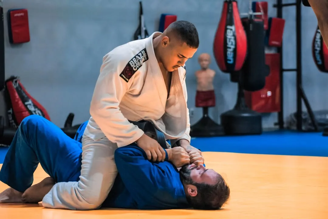 Lutador de quimono branco dominando o adversário de quimono azul