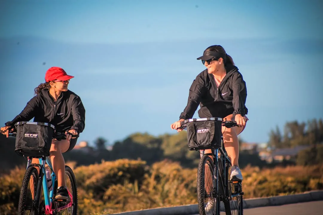 Duas ciclistas pedalando lado a lado