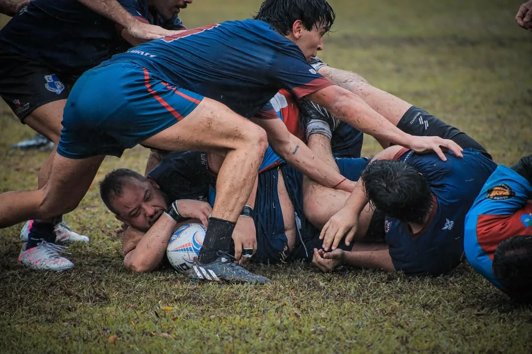 Jogadores de rugby disputando a bola no chão