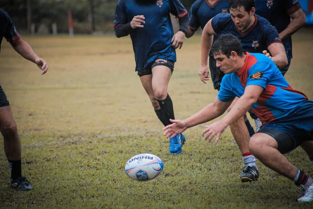 Jogador de rugby buscando a bola no chão