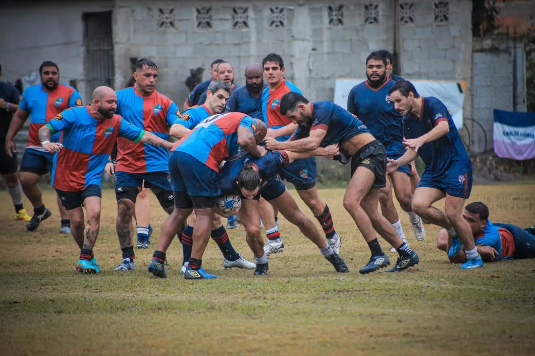 Jogadores de rugby avançando em campo