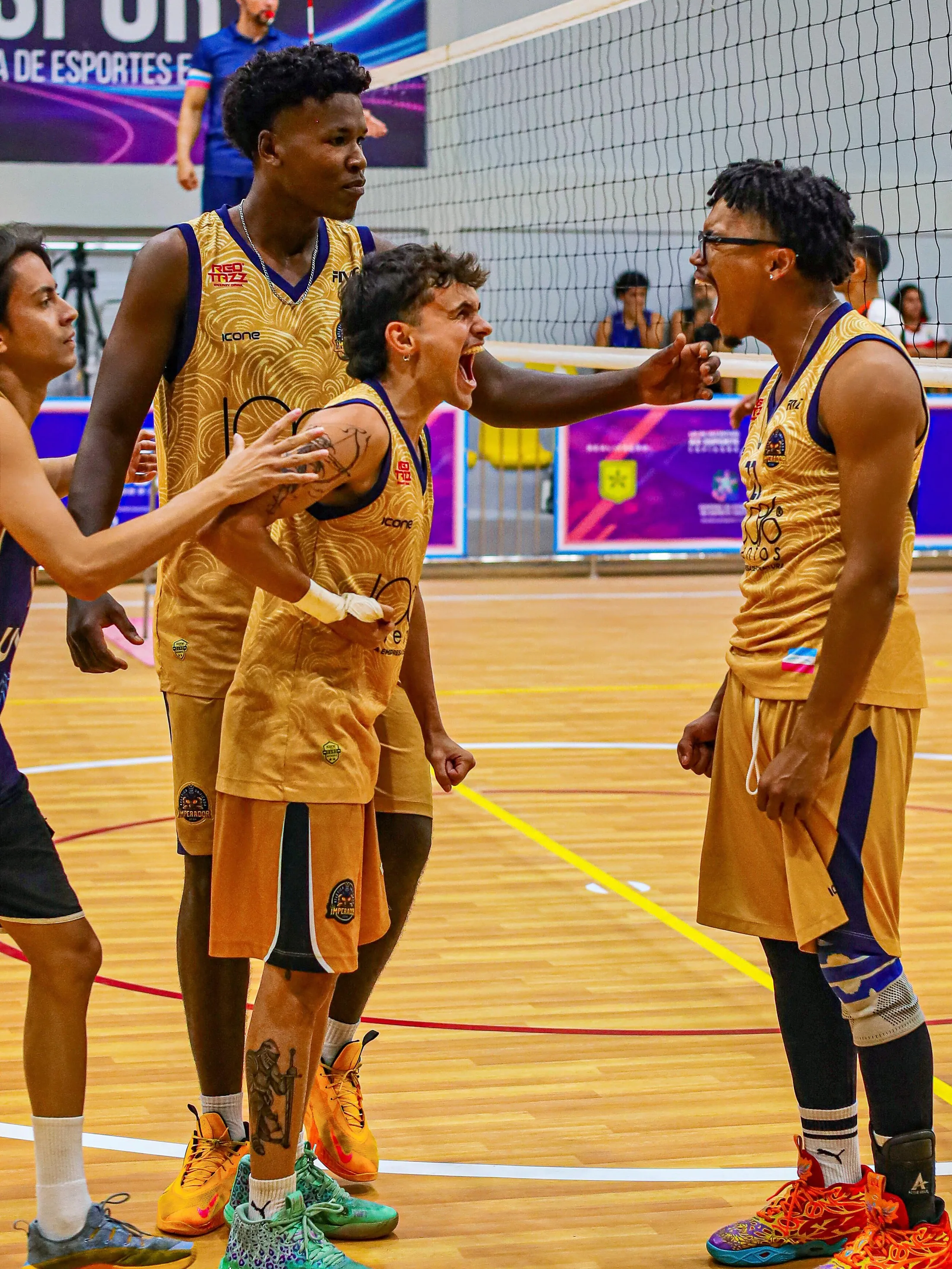 Jogadores de uniforme amarelo reunidos na quadra