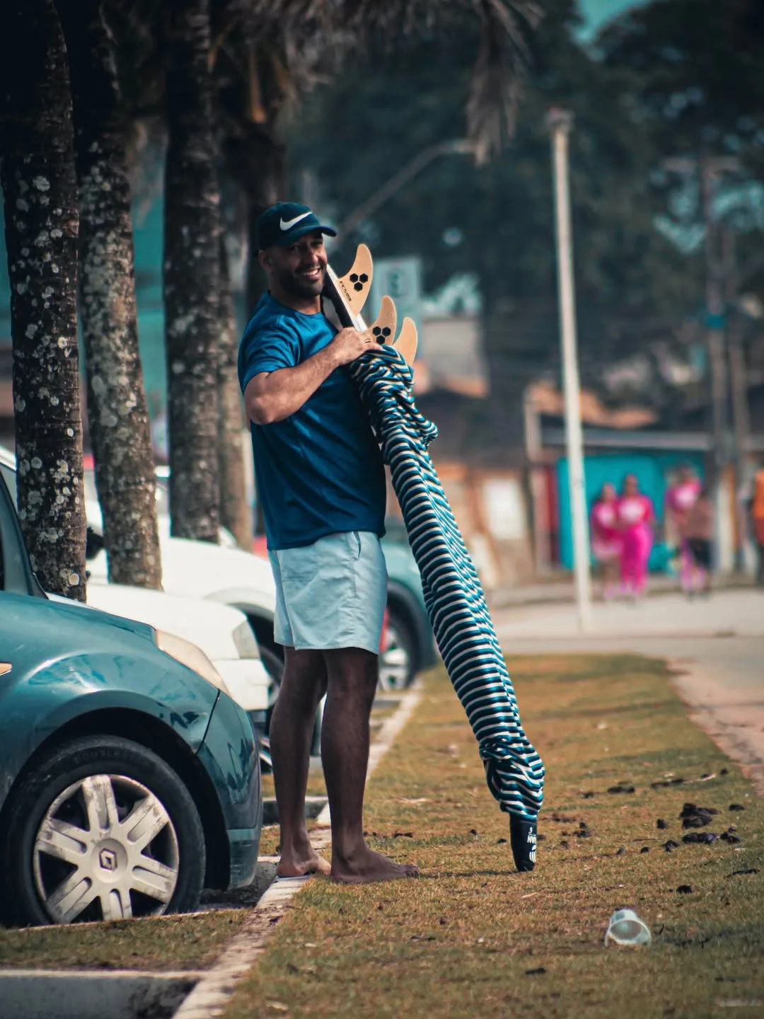 Surfista carregando a prancha na calçada