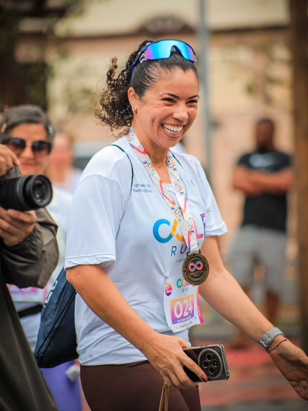 Participante sorrindo com medalha no pescoço